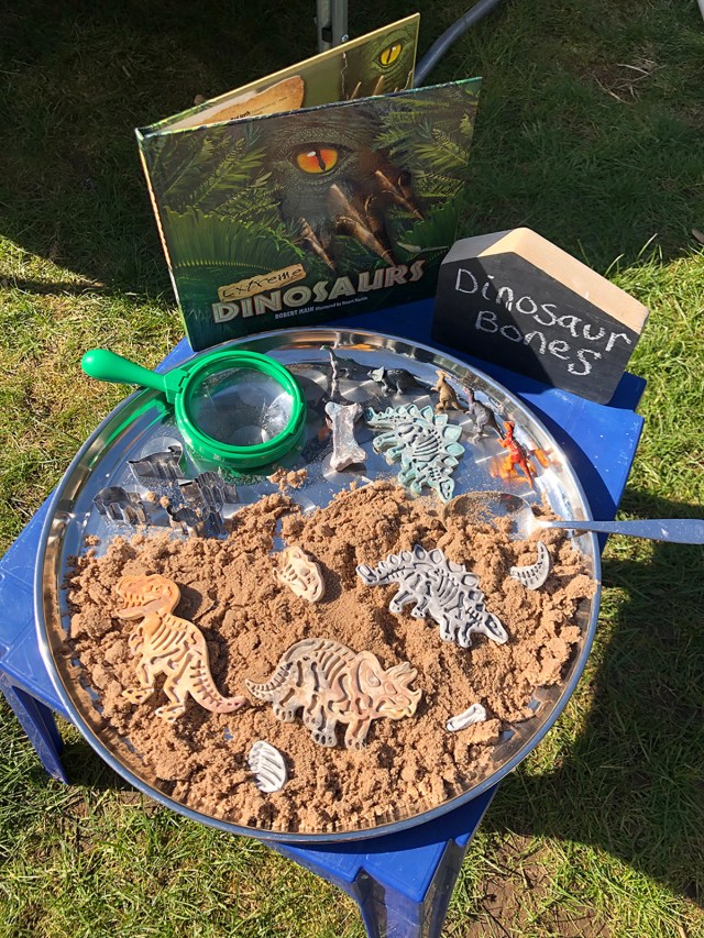 Air dry clay dinosaur bones in a small world discovery tray
