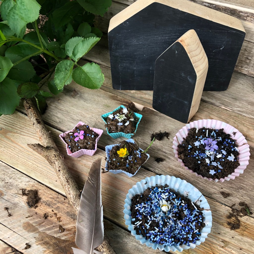 making mud pies and mud buns in our handmade mud kitchen during outdoor play.